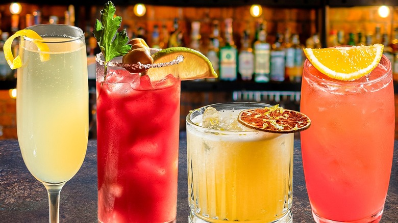 FOUR DRINKS OF STRAWBERRY AND LEMON WITH LEMON WEDGES AND ICE CUBES