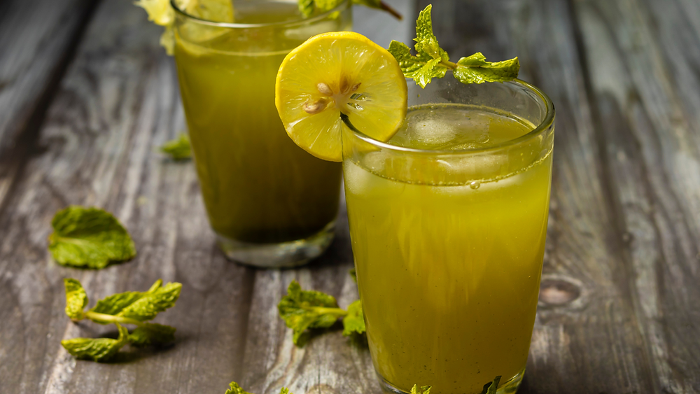 REFRESHING AYURVEDIC MINT LEMON DRINK WITH WEDGED LEMONS AND MINT LEAVES
